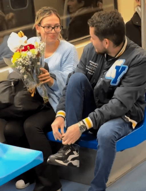 Momento de emoção no metrô de São Paulo, homem surpreende mulher com flores durante a viagem noturna, criando uma conexão sincera e um sorriso inesperado em meio ao cansaço do dia.