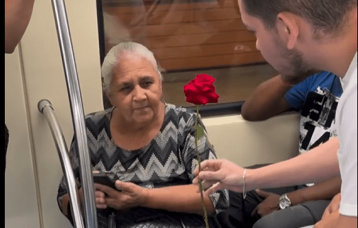 Senhora recebe rosa e bilhete de um homem dentro do metrô de São Paulo, na linha verde, durante um gesto de gentileza e atenção ao próximo.