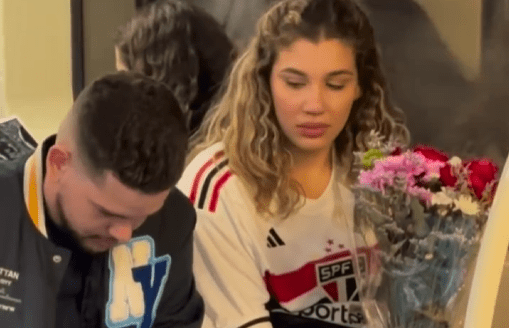 Mulher sentada no metrô de São Paulo, na linha verde sentido Vila Madalena, recebe um buquê de flores e um bilhete motivacional de um homem durante a viagem noturna, em um gesto simples de empatia, incentivo e conexão humana.