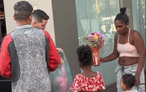 Família com duas crianças é surpreendida por um gesto de carinho na Avenida Paulista em um domingo, recebendo flores, presentes e uma mensagem de esperança em meio ao movimento urbano.